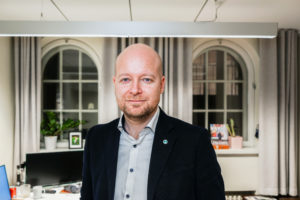 Jussi Saramo seisoo eduskunnan työhuoneessaan.